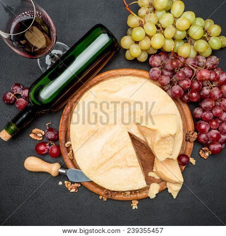 Whole Round Head Parmesan Cheese, Wine And Grapeson Wooden Cutting Board
