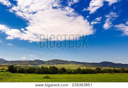 Beautiful Summer Sky Over The Mountainous Area. Lovely Countryside With Forested Hills And Fields