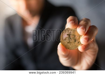 Golden Bitcoin In A Man Hand, Digitall Symbol Of A New Virtual Currency