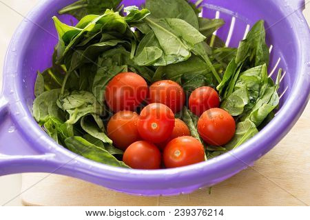 Сherry Tomatoes And Lettuce Leaves Washed In A Colander With Drops Of Water For A Salad For A Diet.