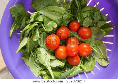 Сherry Tomatoes And Lettuce Leaves Washed In A Colander With Drops Of Water For A Salad For A Diet.