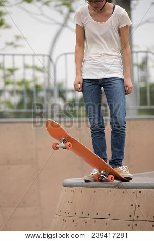 One Woman Skateboarder Sakteboarding On Skatepark Ramp