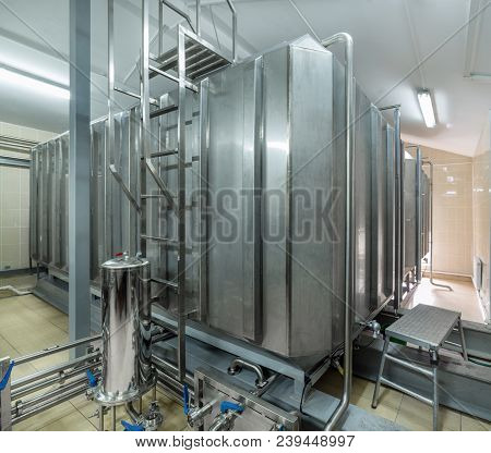 Storage Of Liquid With Stainless Steel Tanks. Large Rectangular Tanks With Piping System For Pumping