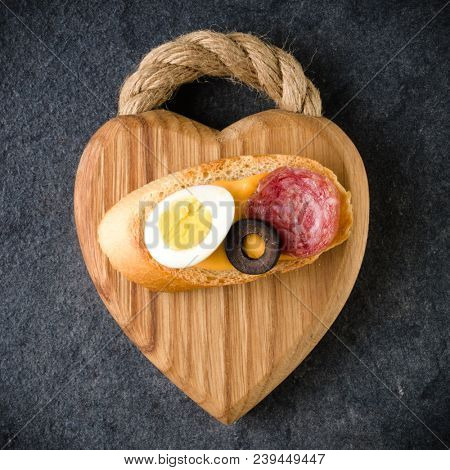 Open faced sandwich canape or crostini on a wooden serving board on dark stone background closeup. Top view. Vegetarian tartarine.