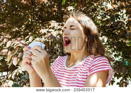 Front View Of A Single Girl Sneezing And Blowing In A Wipe Outdoors With A Green Background