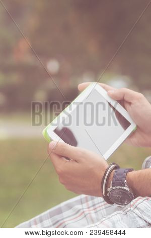 Detail Of A Man Using Tablet In The Park.