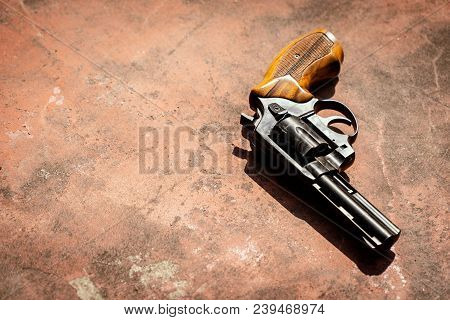Black 9mm Revolver On The Concrete Red Backgroound