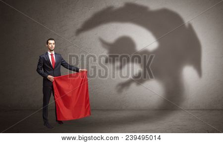 Businessman standing with red cloth in his hand and imp shadow on the background