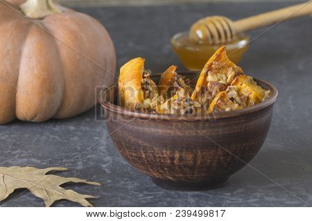 Authentic View Of The Baked Sliced Pumpkin With Honey And Walnuts In A Ceramic Bowl (pial) On A Dark