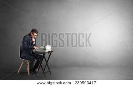 Man working hard on a typewriter in an empty space