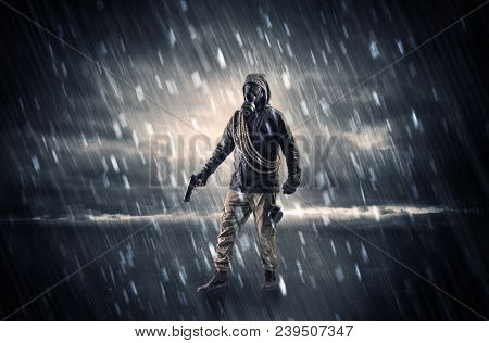 Terrorist in a stormy space with gas mask on his hand and weapons on his arm