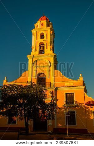 Trinidad, Cuba. The Bell Tower Of San Francisco De Asis Against The Blue Sky. Street In The Center O