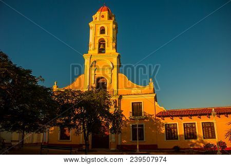 Trinidad, Cuba. The Bell Tower Of San Francisco De Asis Against The Blue Sky. Street In The Center O