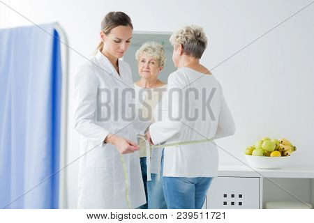 Dietician Taking Measurements Of Patient