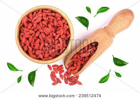 Dried Goji Berries In Wooden Bowl And Scoop Decorated With Green Leaves Isolated On White Background
