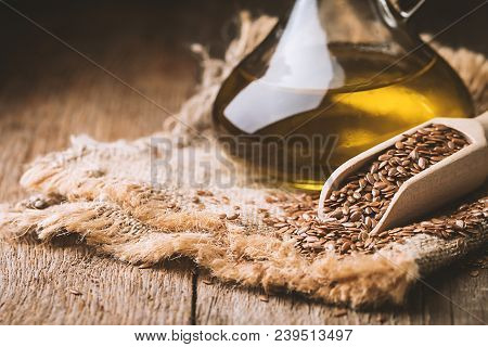 Flax Seeds And Linseed Oil In A Glass Jug On A Wooden Table, Healthy Diet With Omega 3 Fatty Acids