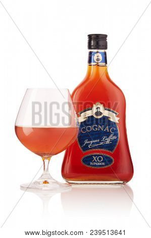 Bottle of cognac Jacques Laffitte XO Superior  and glass with cognac isolated on a white background with reflection.