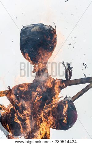 Burning Scarecrow On The Pagan Holiday Pancake Week, Against A Cloudy Winter Sky