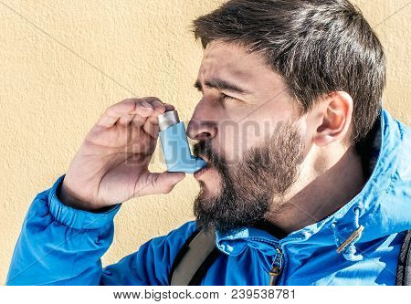 Portrait Of Young Man Using Asthma Inhaler Outdoor