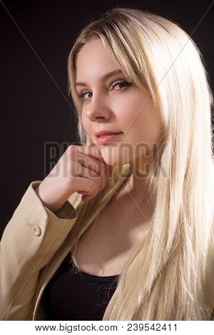 Profile View Of Beautiful Young Woman Looking At Camera With Catty Eyes , On Dark Background