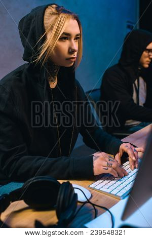 Female Hacker Working On New Malware With Accomplice  In Dark Room