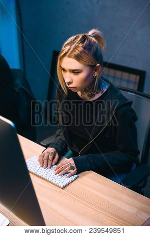 High Angle View Of Serious Young Female Hacker Developing Malware