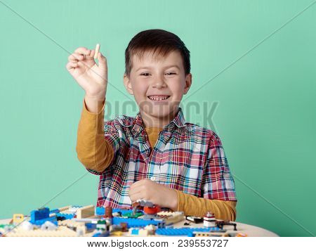 Smiling Caucasian Boy Is Playing Toy Building Blocks. He Is Looking In The Camera.