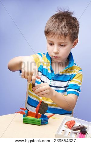 Kid Is Sculpting A Ship With Colorful Modelling Clay.