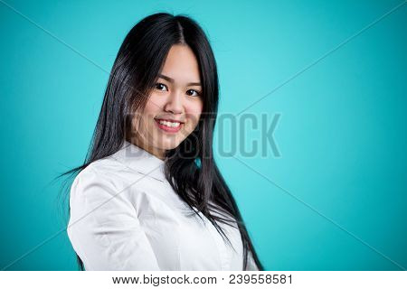 Cheerful Attractive Asian Female Smiling Looling At Camera Isolated On Blue Background
