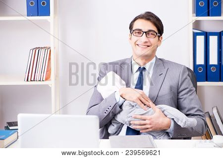 Businessman looking after newborn baby in office