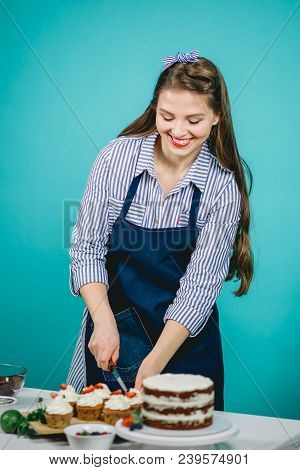 White Smilyng Hairstyled Woman With Headband Decorating Tasty Cake With Fresh Berries In Studio