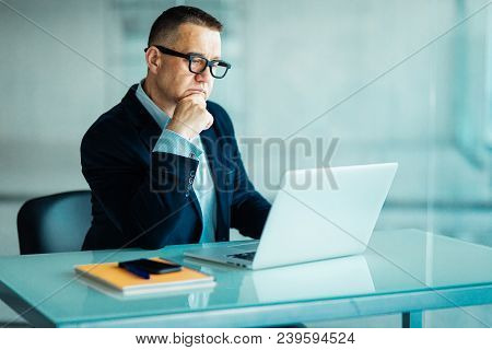 Senior Man In Modern Office Working On Laptop Computer