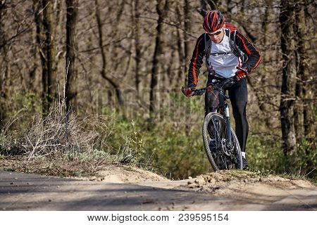 Cyclist In Sports Clothes Is Driving On The Roadless In The Forest.