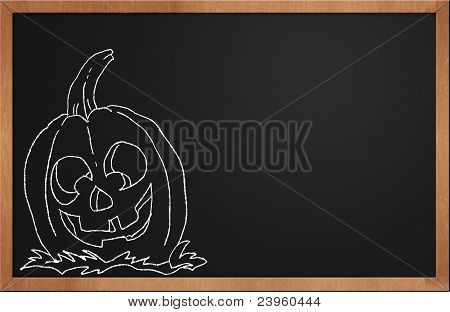 Zucca di Halloween sorridente su una lavagna nera