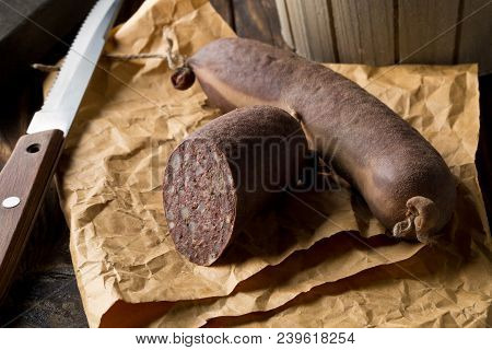 German Specialty Blood Sausage (blutwurst) On Wooden Table In Kitchen