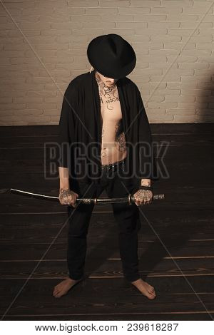 Honor And Dignity. Man With Sword Standing On Wooden Floor Barefoot, Top View. Samurai, Buddhist Con