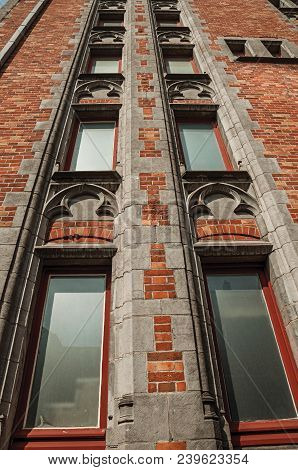 Brick Facade Of Buildings In Typical Flanders Style And Blue Sky At Bruges. With Many Canals And Old