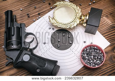 Best Shooter Award Background With Copy Space. Winner In Shooting. Gun, Paper Target And Gold Medal.