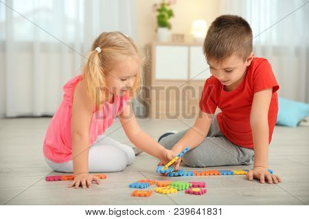 Cute little children playing with pazzles at home