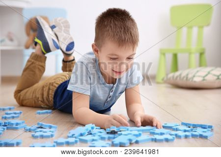 Cute little boy playing with pazzles at home