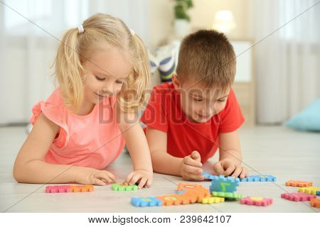 Cute little children playing with pazzles at home