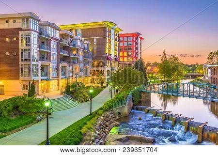 Greenville, South Carolina, USA downtown cityscape on the Reedy River at dusk.