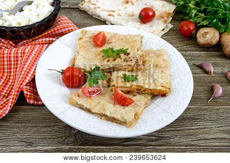 Pie, Casserole Pita With Mushrooms, Cottage Cheese And Cheese On A White Plate On A Wooden Backgroun