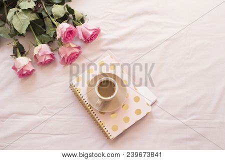 Coffee In Bed On Pink Sheets. Roses, Notebooks Around. Freelance Fashion Home Femininity Workspace