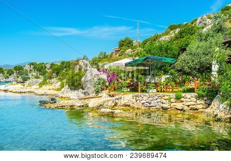 The Small Tourist Cafe With Summer Terrace In Garden On The Rocky Coast Of Kekova Bay, Turkey.