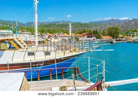 The View On Scenic Ucagiz Village Behind The Row Of Yachts In Its Harbor, Kekova, Turkey.