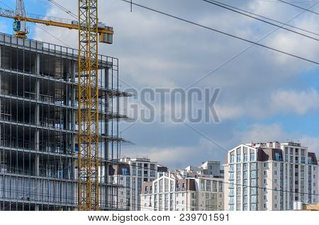 Construction Site With Crane And With Unfinished Skeleton Of A High-rise Building Made Of Reinforced