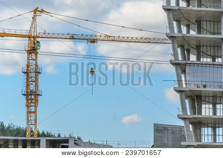 Construction Site With Crane And With Unfinished Skeleton Of A High-rise Building Made Of Reinforced