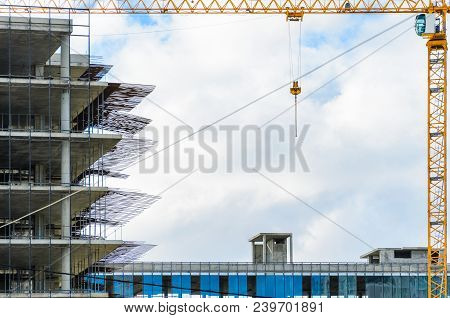 Construction Site With Crane And With Unfinished Skeleton Of A High-rise Building Made Of Reinforced