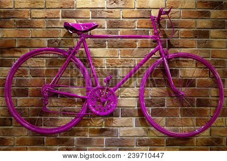 Red Bicycle On A Brick Wall. Unusual Beautiful Pink Tones.